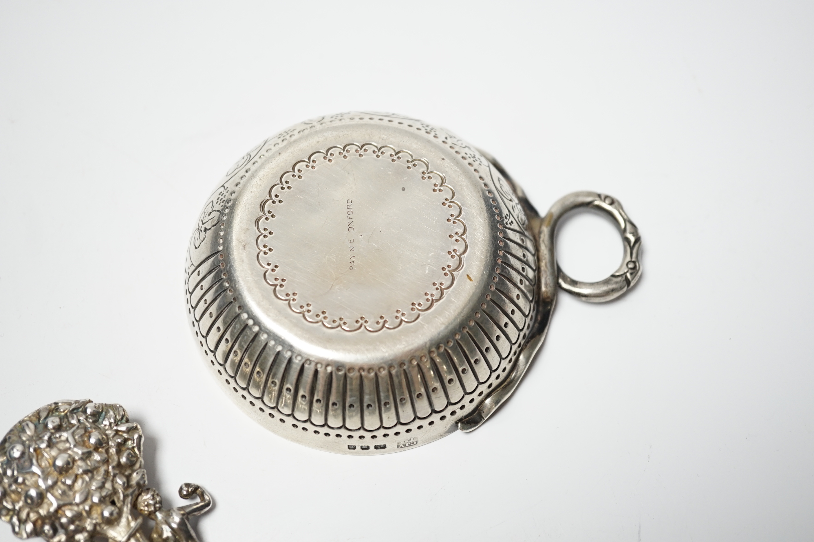 A George V silver taste vin, C.J. Vander Ltd, London, 1932, diameter 81mm, together with a Hanau ornate silver spoon, depicting Adam and Eve with the serpent, import marks for Berthold Muller, London, 1903, 14cm.